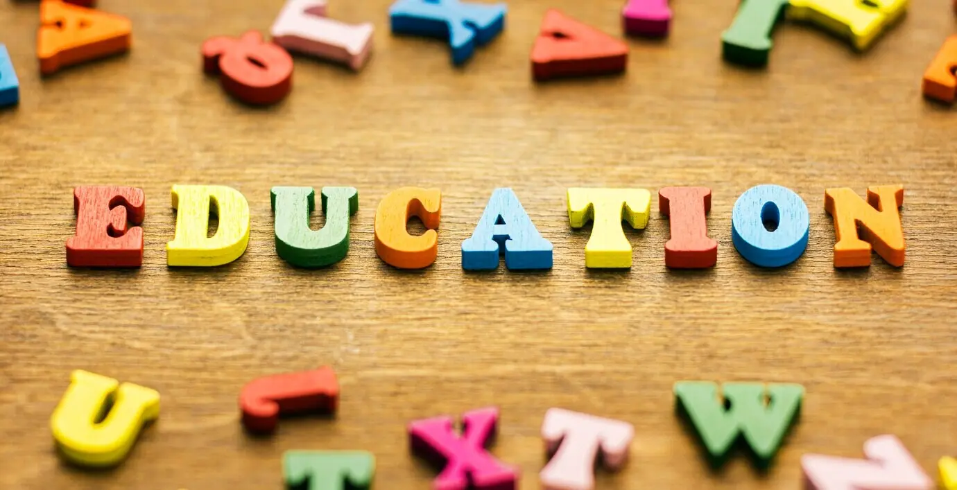 Blick von oben auf Buchstaben, die „education“ bilden.